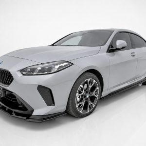 Front three-quarter view of a silver BMW sedan in a studio setting, featuring a large black kidney grille and stylish alloy wheels.