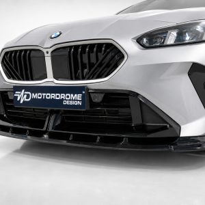 Close-up of a silver car front with a bold black grille and a Motordome Design plate visible on the bumper