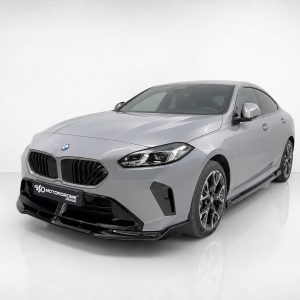 Silver BMW sedan in a studio setting, front three-quarter view showcasing the grille and alloy wheels.