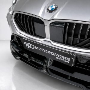 Close-up of a silver BMW front end, showing the badge and a black license plate with 'MD Motordome Design' text across it.