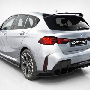 Rear three-quarter view of a silver BMW hatchback with large alloy wheels and a black rear spoiler in a studio setting, showing curvy body lines and red taillights.