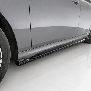 Close-up of a sleek silver car's side, showing the door, alloy wheel, and side skirt on a glossy floor.