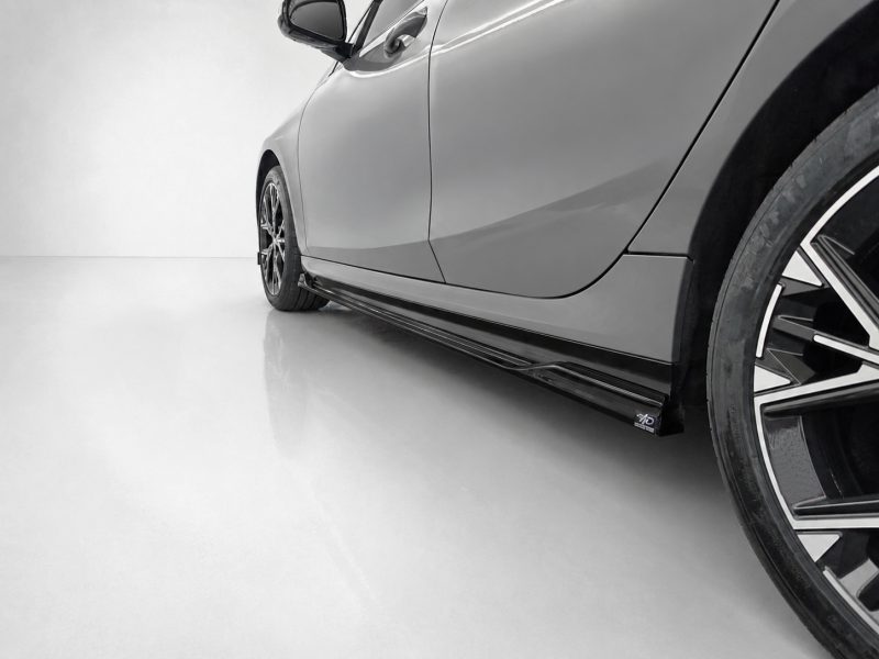 Gray sports car's side close-up, showing a lowered body and glossy side skirt near the wheel edge.