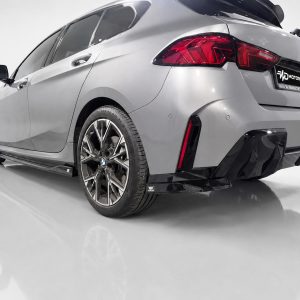 K215-004_4jpg - OPSHOLDERS Rear three-quarter view of a silver BMW with a carbon fiber aero kit in a studio setting.
