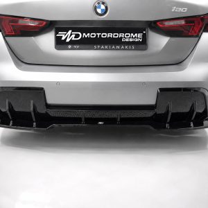 Rear view of a silver BMW 120 with a large black aftermarket diffuser, red taillights, and a Motordrome Design plate.