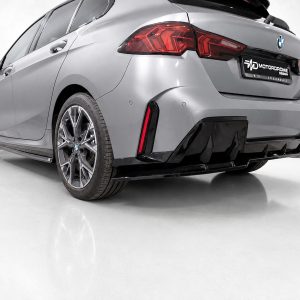 Rear three-quarter view of a silver BMW with an aggressive black-body kit and diffuser, parked on a white studio floor