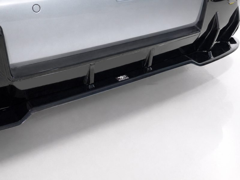 Close-up of a black running board along the bottom of a silver SUV bumper with a small emblem in the center.