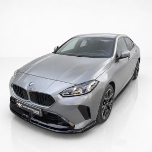 Silver BMW sedan photographed from a low front-left angle in a white studio setting