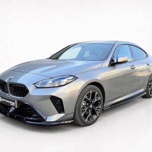 Front three-quarter view of a silver BMW sedan with a bold black grille, photographed in a bright white studio setting.
