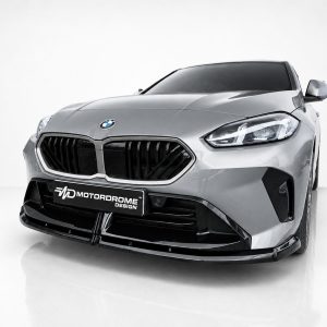 Front view of a silver sports car in a studio, highlighting its black grille and sleek headlights; MotorDrome Design plate visible on the bumper.
