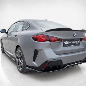 K215-008_2jpg - OPSHOLDERS Rear three-quarter view of a gray BMW with a large rear spoiler and aggressive diffuser in a studio setting
