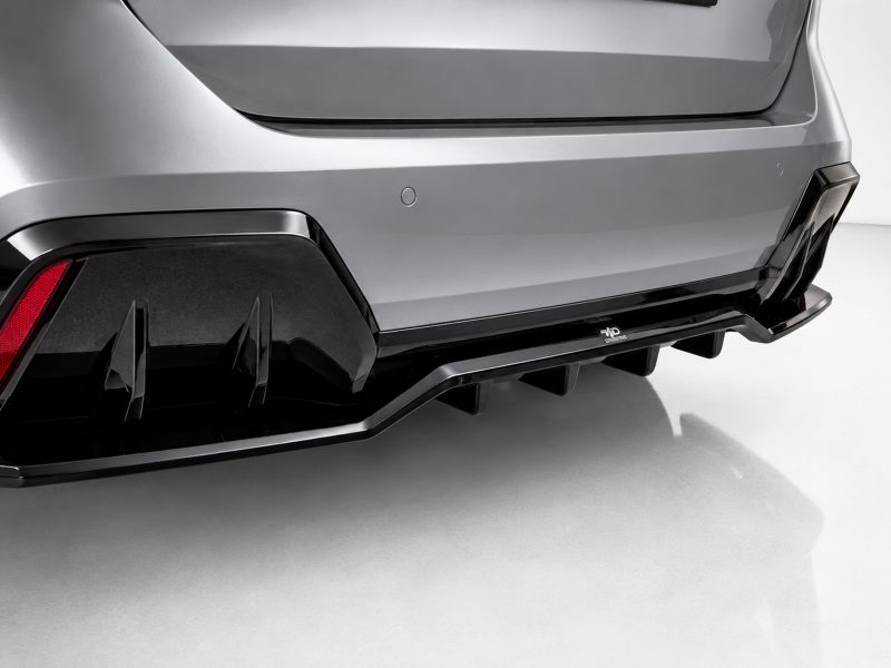 K215-008_5jpg - OPSHOLDERS Rear view of a silver sports car showing an aggressive black diffuser and angular taillights on the bumper area. | Close-up of the car's rear bumper highlighting a glossy black diffuser and red taillight panel.