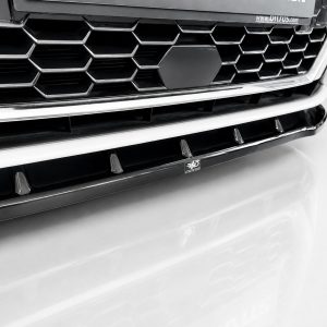 Close-up of a car's front grille with a honeycomb pattern and chrome trim, with a central badge.