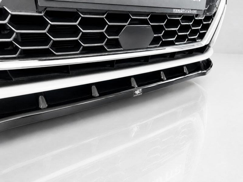 Close-up of a car's front grille with a honeycomb pattern and chrome trim, with a central badge.