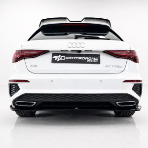 Rear view of a white Audi A3 with a black MD Motorodrome Design plate, taillights lit, and a sporty rear bumper.