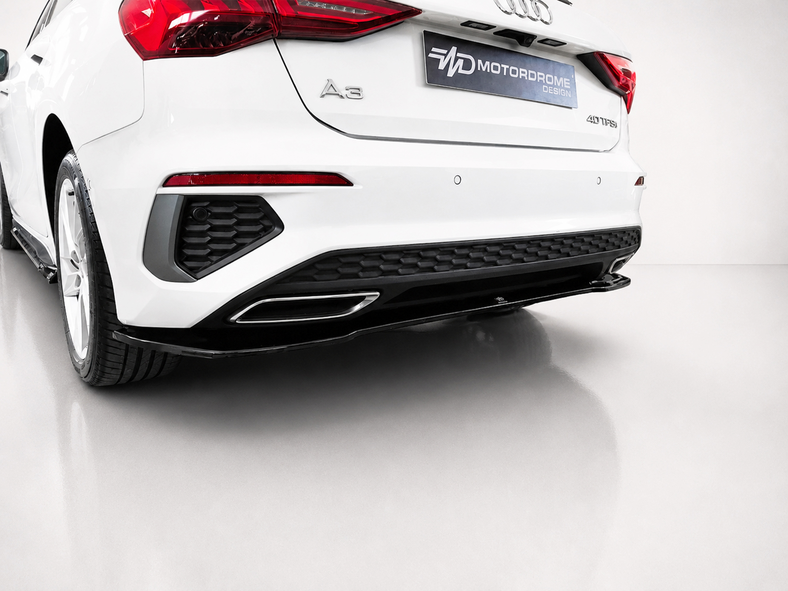 K216-003_2jpg - OPSHOLDERS Rear three-quarter view of a white Audi A3 SUV, showing taillights, badge, and hex-pattern rear diffuser with a dark bumper area