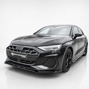 Front three-quarter view of a black Audi sedan in a white studio, showing a bold grille, sharp LED headlights, and MD Motordrome Design plate.