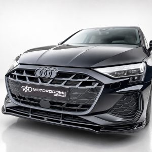Front view of a dark gray Audi with a prominent grille and 'Motordome Design' plate in a studio setting