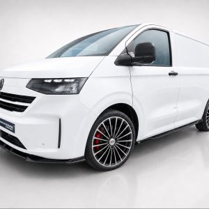 White cargo van with large multi-spoke alloy wheels and red brake calipers, shown from a low-angle front-right view in a studio setting