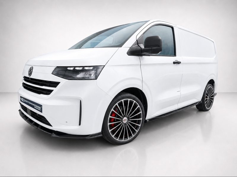 White cargo van with large multi-spoke alloy wheels and red brake calipers, shown from a low-angle front-right view in a studio setting
