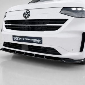 Front view of a white Volkswagen van with a custom splitter and black grille, displaying a Motordrome Design plate plate on the bumper.