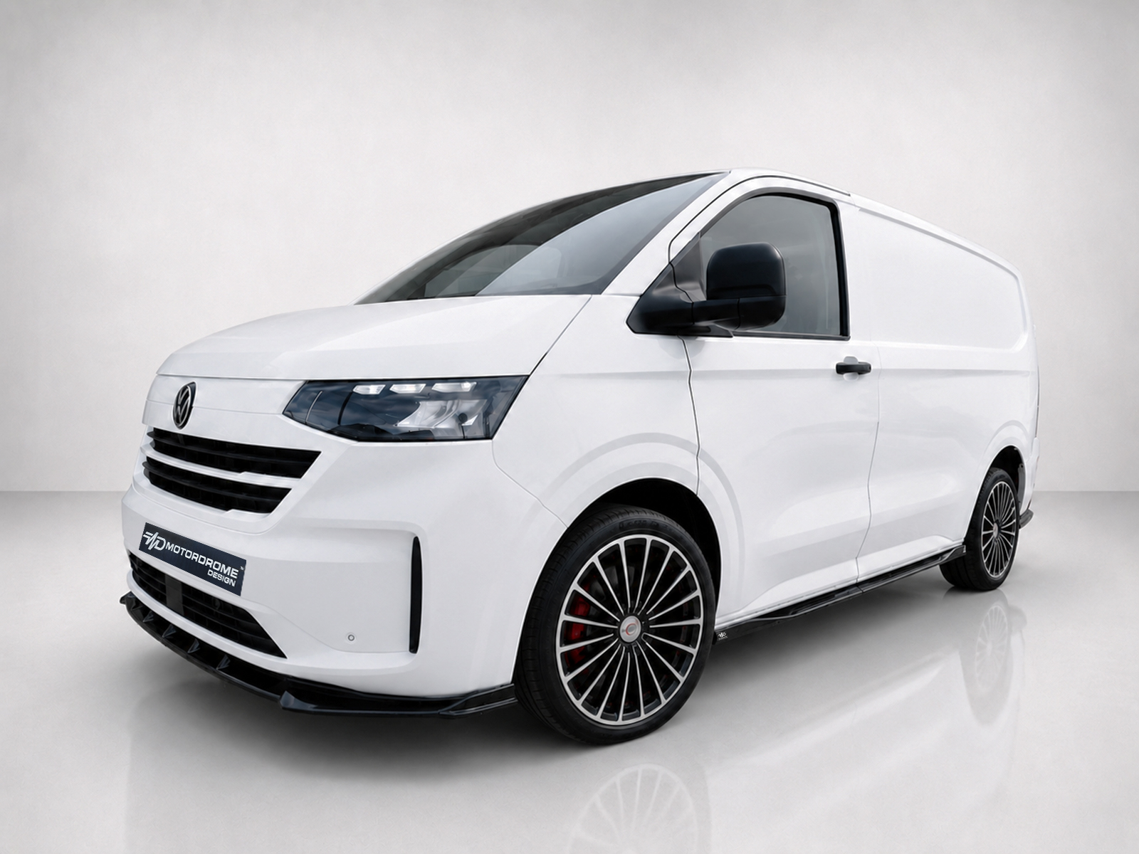 K217-004_1jpg - OPSHOLDERS Three-quarter front view of a white modern van with black grille, large alloy wheels, and a clean glossy finish in a studio setting.