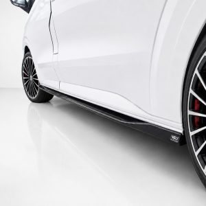 K217-004_2jpg - OPSHOLDERS Close-up of a white car’s side with a large multi-spoke alloy wheel and red brake calipers visible through the rim.