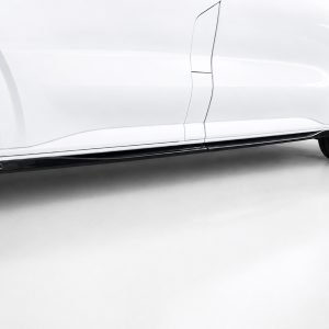 K217-004_3jpg - OPSHOLDERS Side view of a white sports car showing the black lower side skirt and stylish multi-spoke wheels with red brake calipers in view.