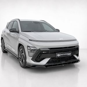 Three-quarter front view of a white Hyundai SUV with a black aftermarket front bumper and side skirts, in a bright studio setting with a branded license plate read 'Motordrome Design'.