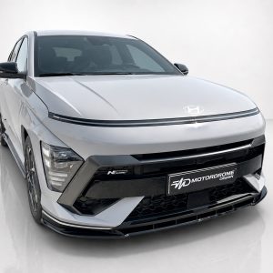 Front three-quarter view of a white Hyundai SUV with black trim and a Motordrome Design license plate on the front bumper.