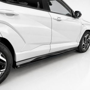 Side view of a white SUV showing doors, sculpted panels, and large alloy wheels with black trim distance edge to edge view]