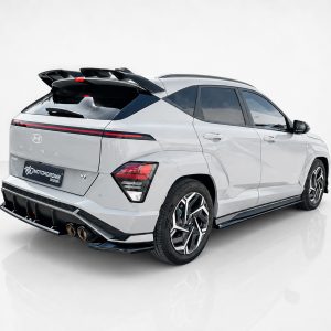 K219-003_3jpg - OPSHOLDERS Rear three-quarter view of a white Hyundai Kona-style SUV with a large aftermarket rear spoiler and racing-style wheels in a studio setting