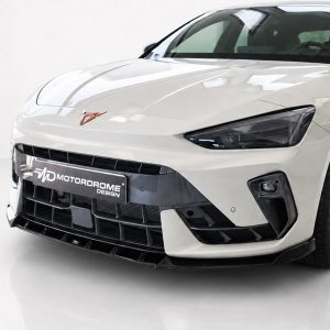 Front view of a white sports car with a bold black grille and angular headlights, license plate reading 'Motordrome Design'