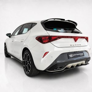 Rear view of a white CUPRA hatchback with a dark spoiler and distinctive red taillights in a showroom setting