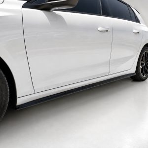 Side view of a white sedan with black alloy wheels and tinted windows.