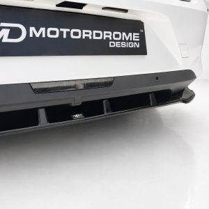 White car front bumper with a black lower lip diffuser and a small MD Motordome Design badge