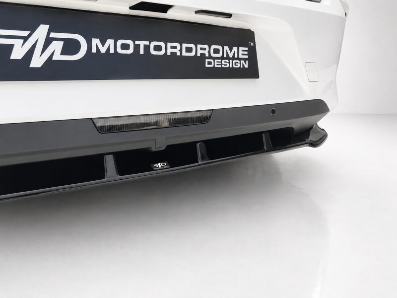 White car front bumper with a black lower lip diffuser and a small MD Motordome Design badge