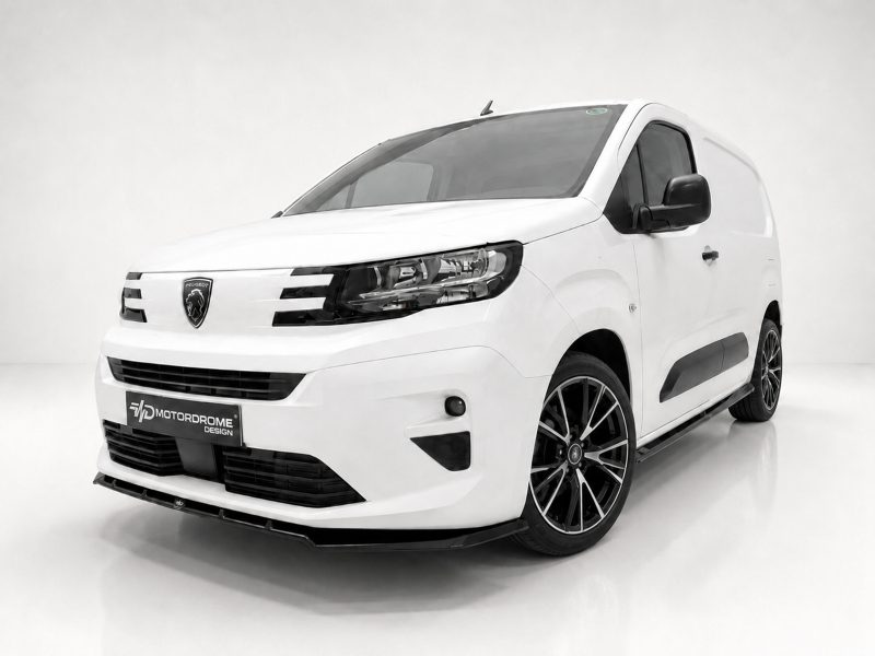 White Peugeot cargo van viewed from the front-left in a studio, showing black alloy wheels and a Motordrome Design plate on the bumper.
