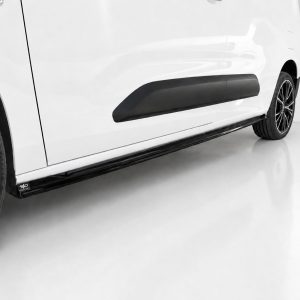 K222-002_3jpg - OPSHOLDERS Close-up of a white car's side showing the black running board and rear wheel on a glossy floor