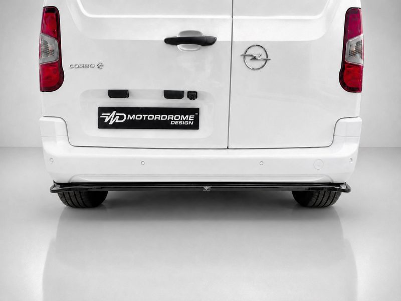 Rear view of a white van with two rear doors, Opel badge on the right, and a Motordrome Design plate in the center.