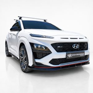 White Hyundai SUV from a three-quarter front view with a roof rack, photographed in a bright studio setting.