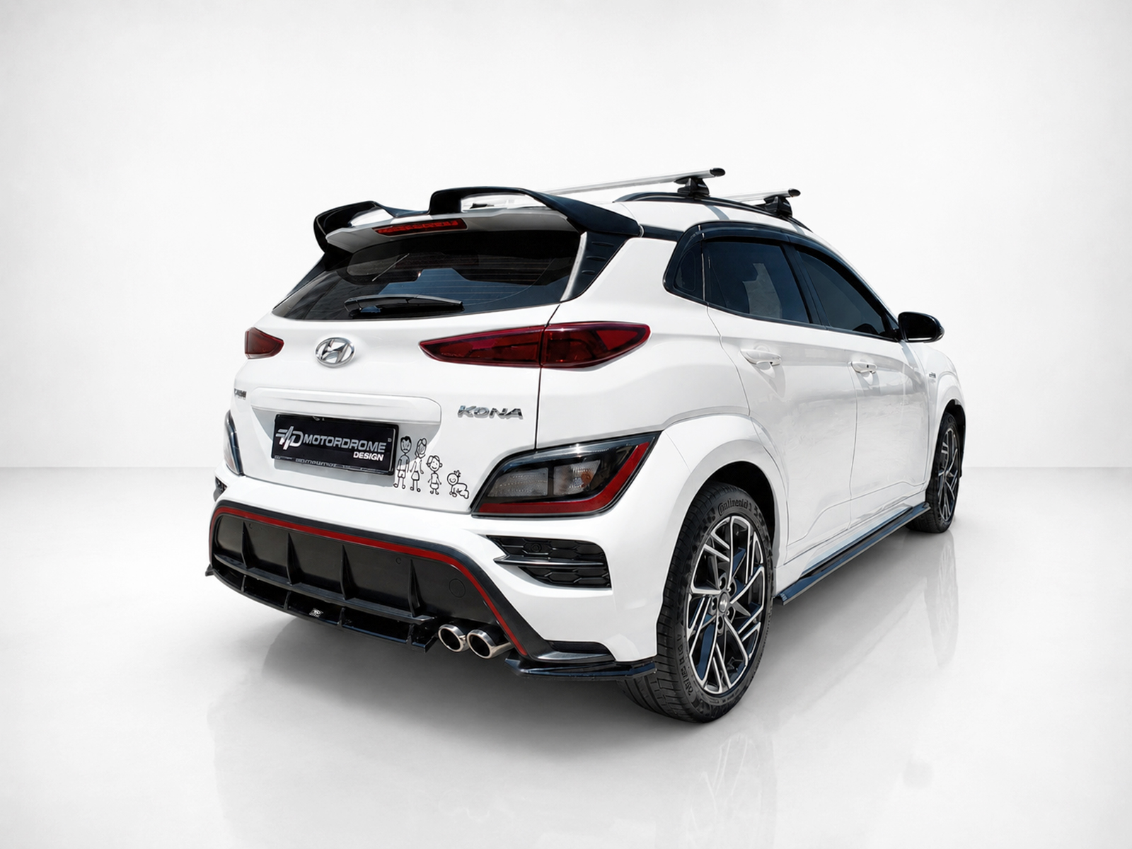 K223-003_1jpg - OPSHOLDERS Rear three-quarter view of a white Hyundai Kona with a black diffuser, dual exhausts, and roof rack accessories in a studio setting.