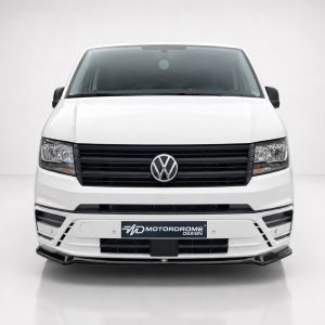 Front view of a white Volkswagen van facing the camera, with a black grille and VW emblem in the center, showroom background.