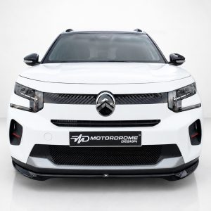 Front view of a white SUV with a black grille and emblem, displaying a Motorsport Design plate at the bumper edge.