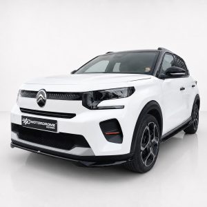 Front three-quarter view of a white SUV with black grille and large alloy wheels in a studio setting.