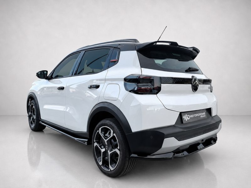 White compact SUV shown from a rear three-quarter angle, with black roof, alloy wheels, and Motorodrome Design badge in a studio setting.