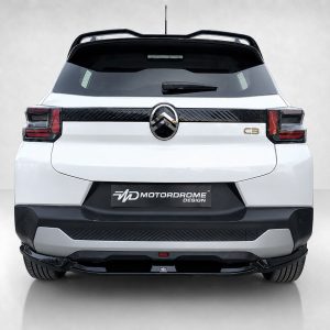 White SUV viewed from the rear, showing taillights, rear window wiper, roof rails, and a Motordrome Design license plate area