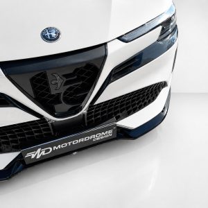 Close-up of a white car front showing the Alfa Romeo badge, sleek headlight, and black mesh grille.