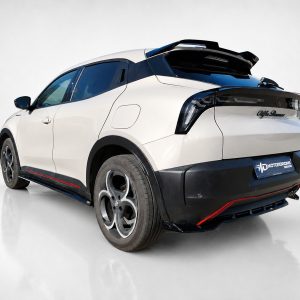 White futuristic SUV from rear-left angled view, showing taillights, black roof spoiler, and red accent on the rocker panel.
