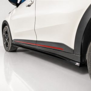 White car side with black side skirts and a red accent stripe along the lower body line